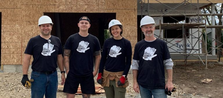 Dairyland Group poses in front of the Habitat Build they were volunteering at on Volunteer Day 2022