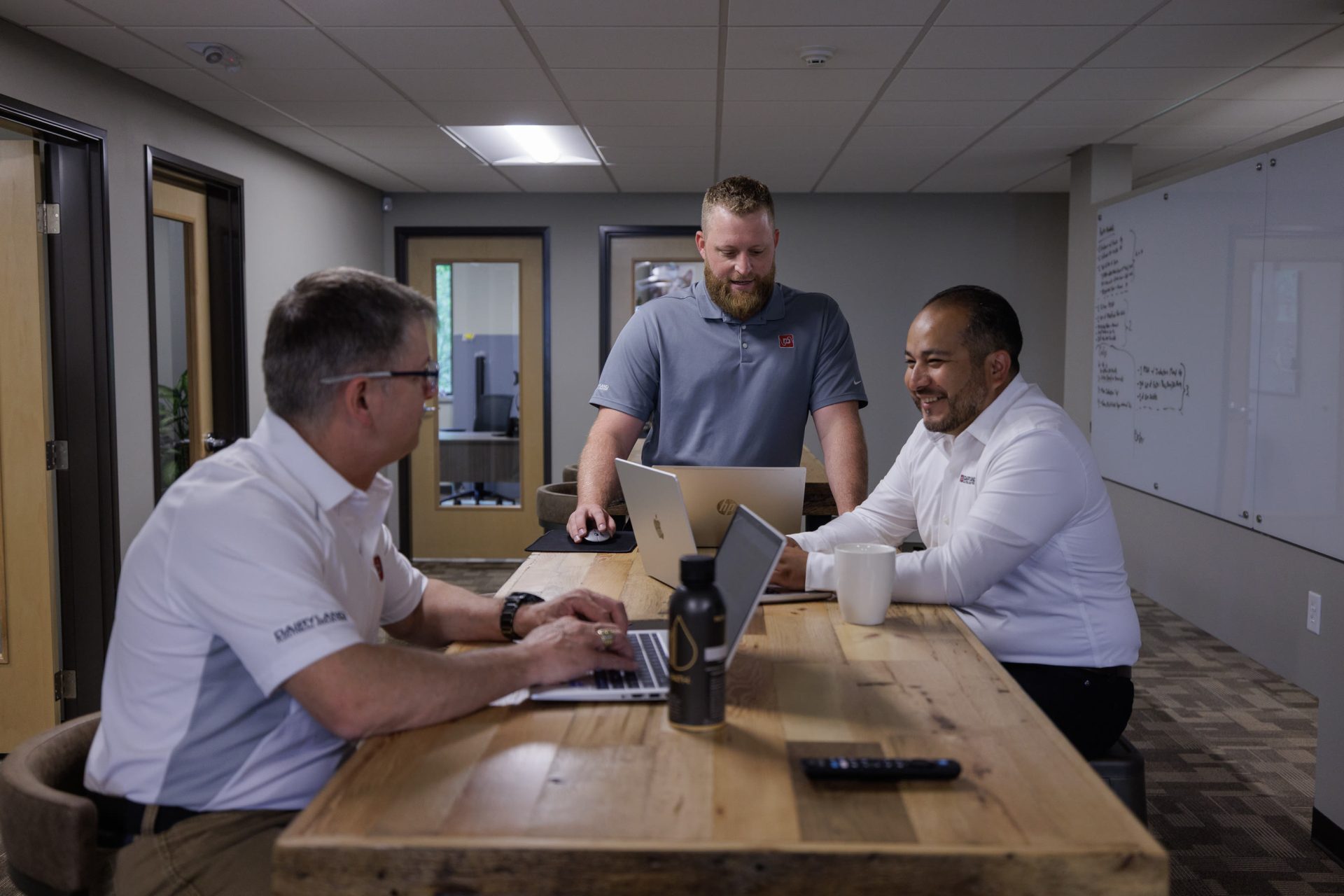 Three Dairyland team members gathered around a laptop