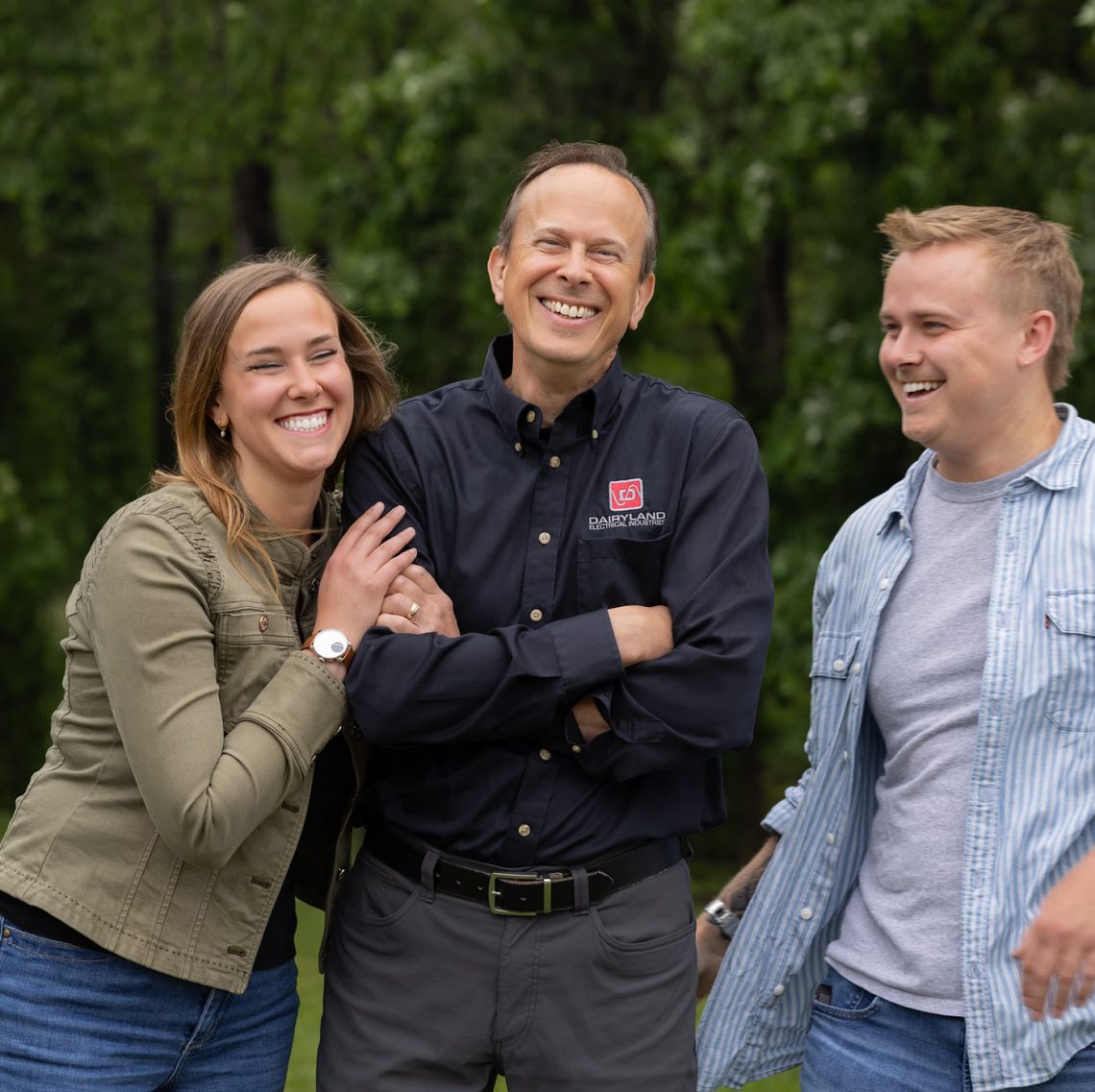 Three members of the Tachick family smiling outdoors